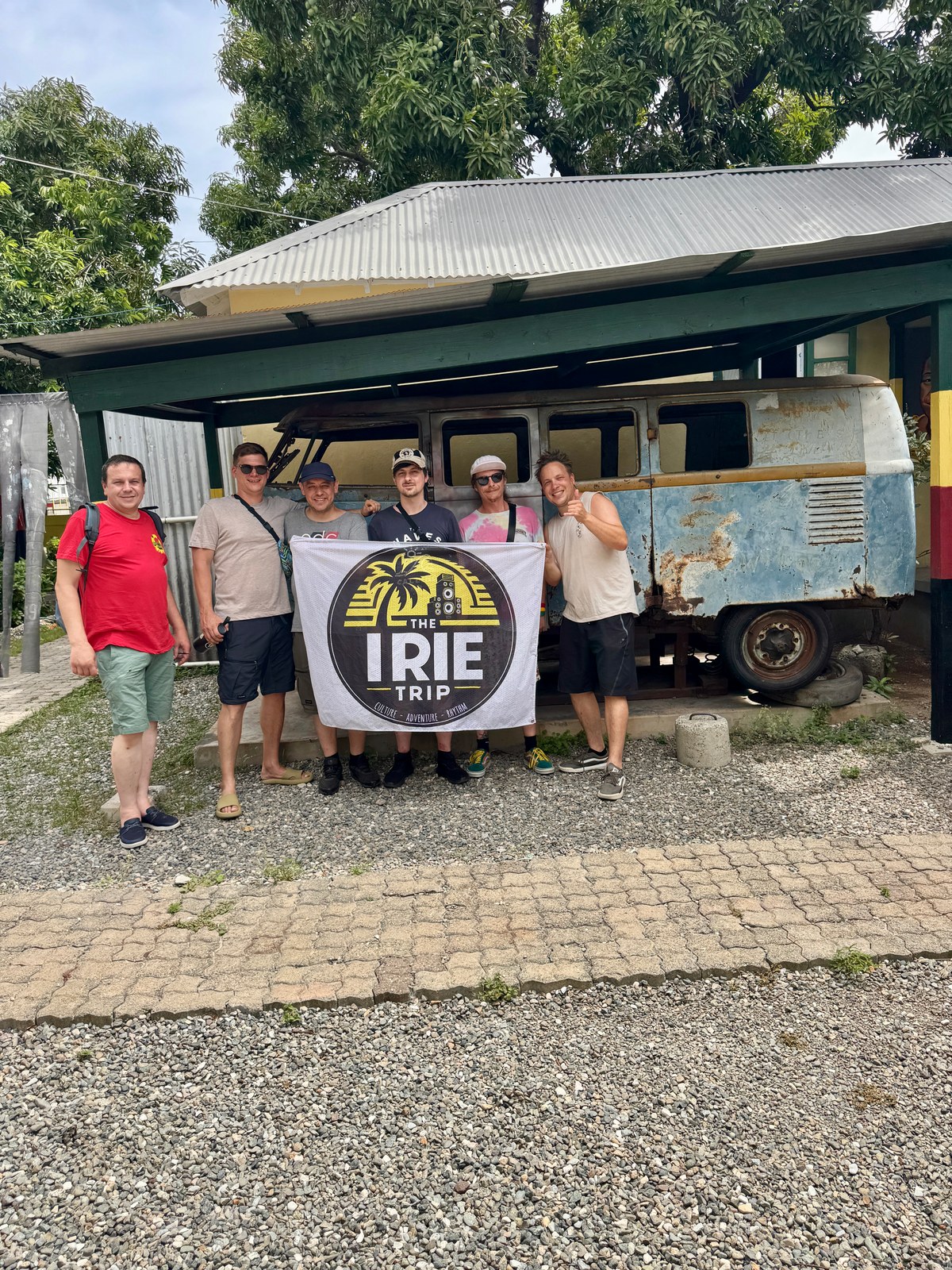 A previous group with the Irie Trip flag in front of an old VW bus
